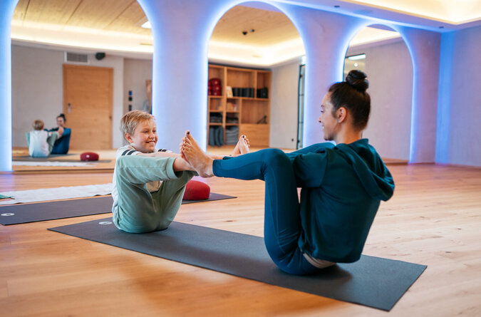 Mutter und Sohn praktizieren gemeinsam Yoga im familienfreundlichen Hotel Mutter und Sohn machen zusammen Yoga in einem familienfreundlichen Hotel.